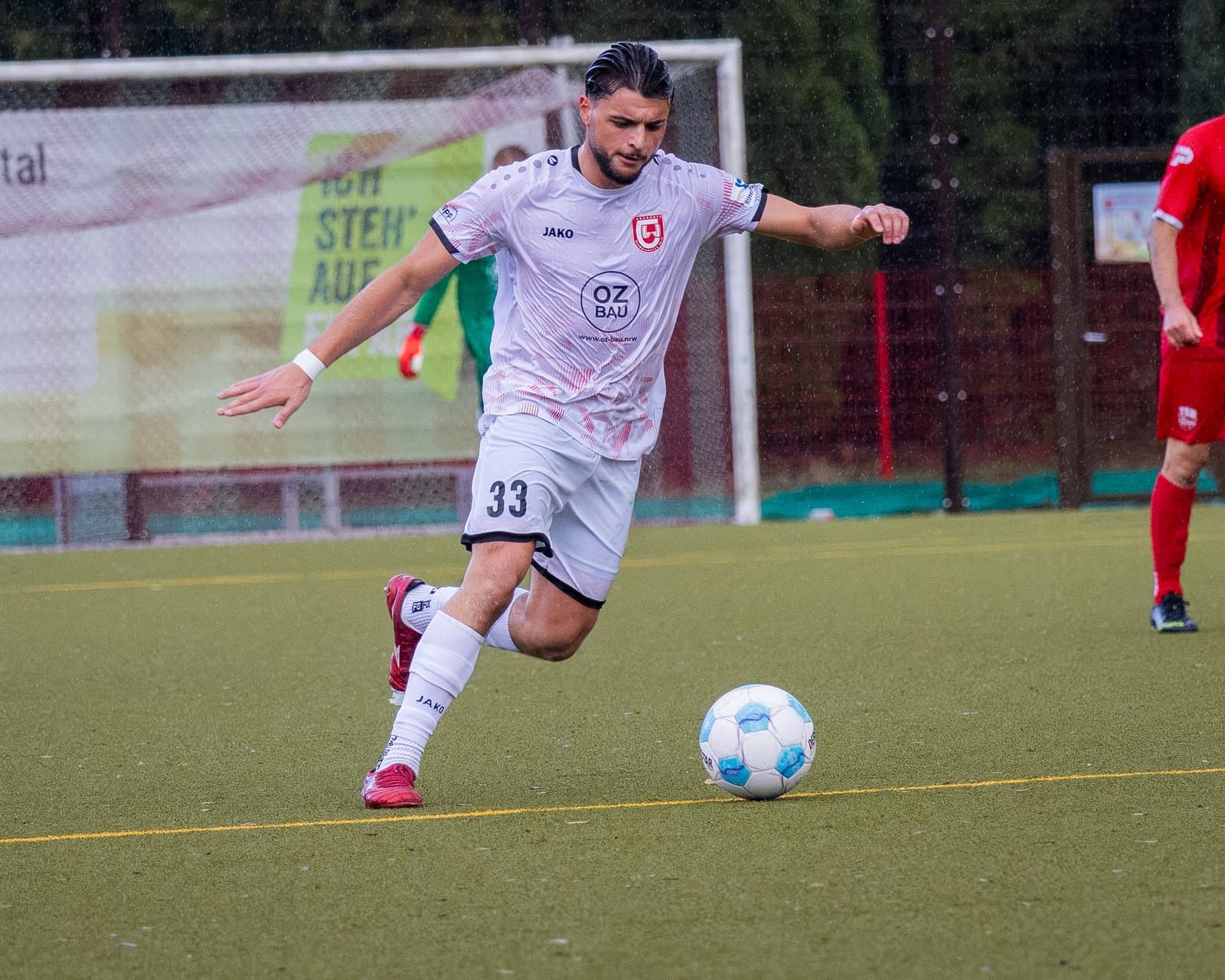 Alessandro Marino mit der Nummer 33 beim Torschuss auf nassem Rasen