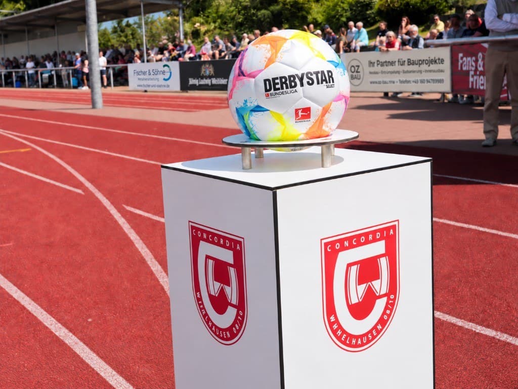 Spielball auf einem Podest mit Concordia-Wappen vor der Tribüne am Sportpark Glücksburger Straße